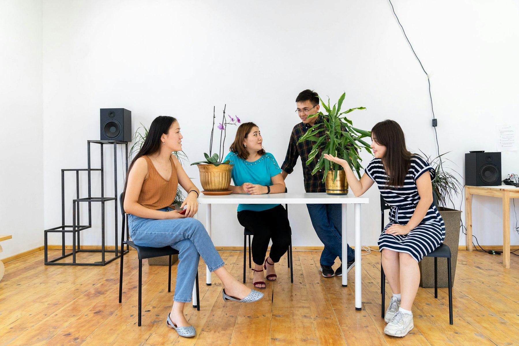 Quatro empresários quirguizes conversam à volta de uma mesa.