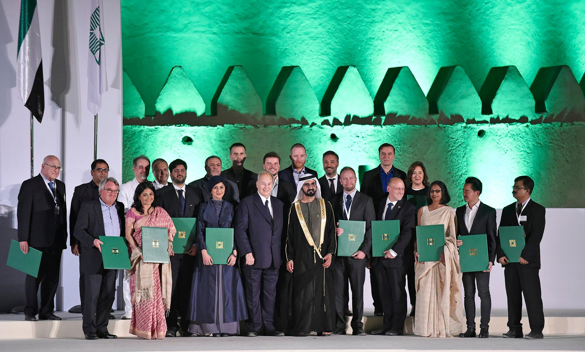 Aga Khan Award for Architecture winners stand on stage, holding their awards.