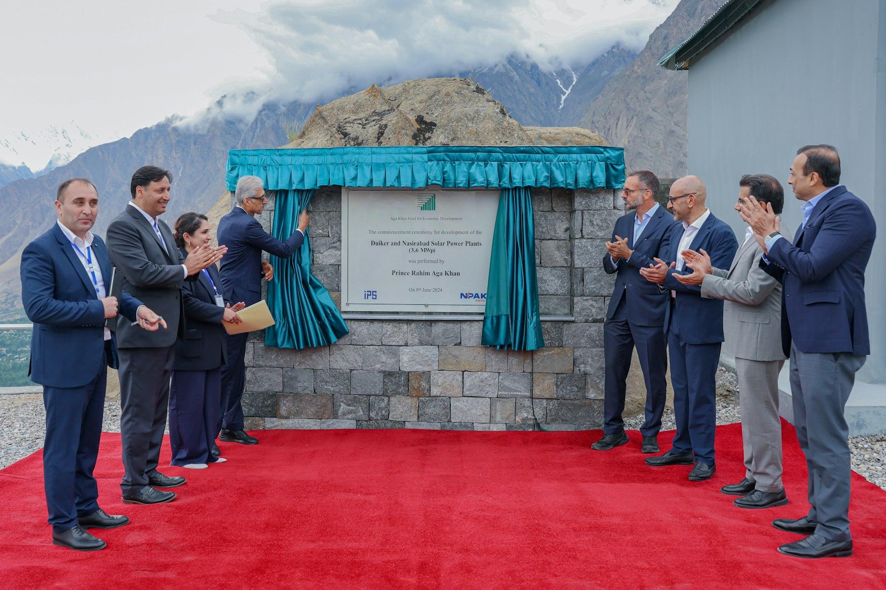 A plaque is unveiled and a group of eight people applaud.