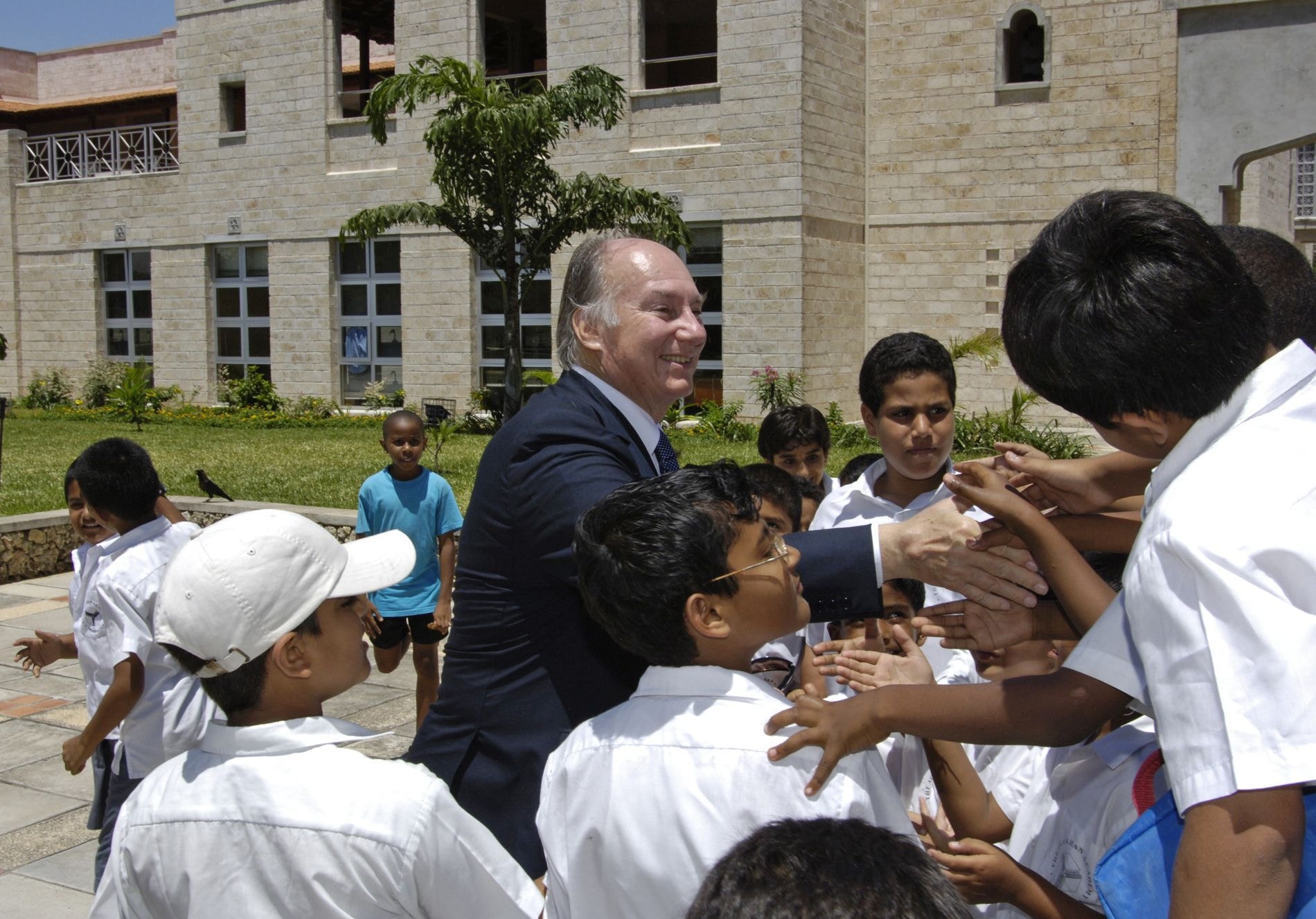 His Late Highness Aga Khan IV greets students on a visit to the Aga Khan Academy in Mombasa, Kenya.