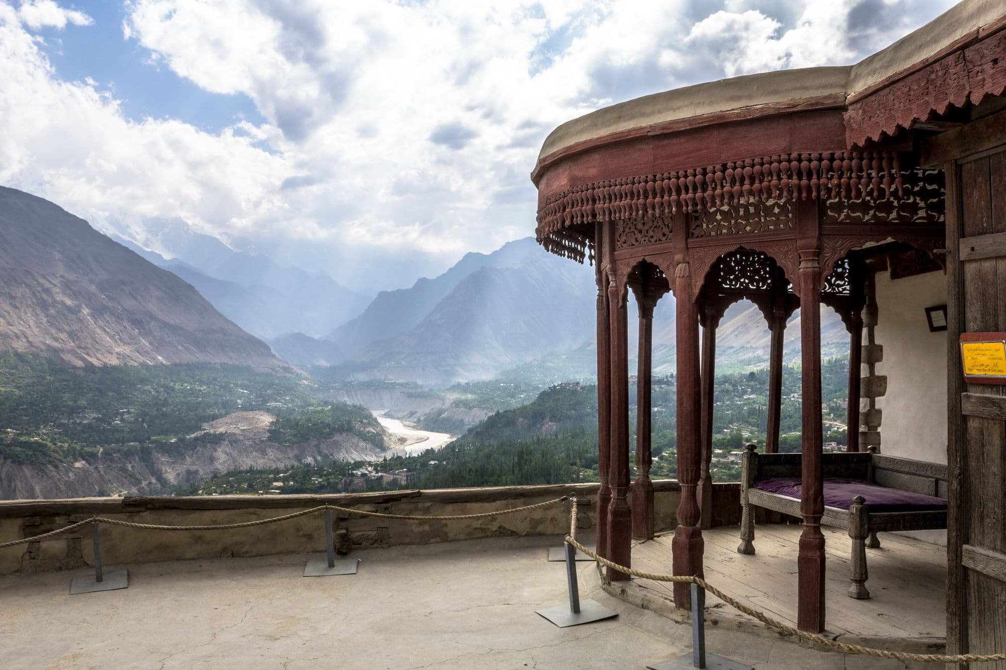 A corner of the restored Baltit Fort with a view of the mountains, river and sky beyond.