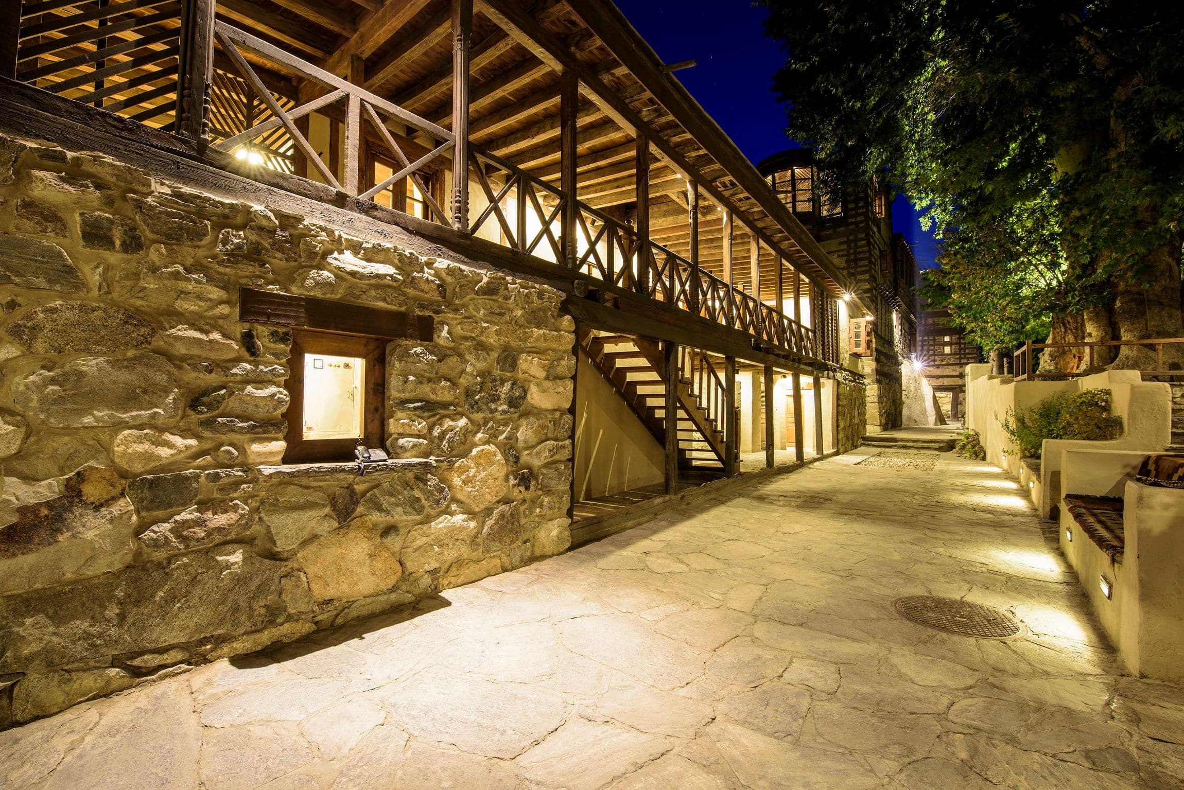 The wood and stone Serena Shigar Fort Hotel, lit up at night.