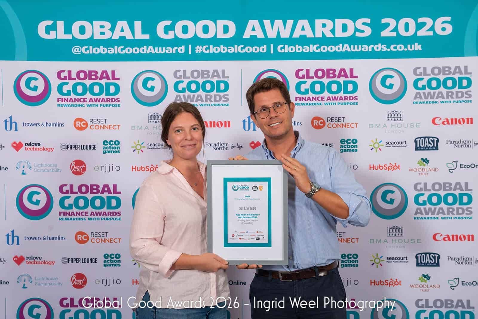 A man and woman accept Schools2030's award at the Global Good Awards 2026